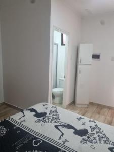 a bedroom with a bed and a bathroom with a refrigerator at Hotel santa Rosa spa in Ovalle
