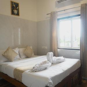a bedroom with two twin beds with a window at Amani Beach Stay in Māvalli