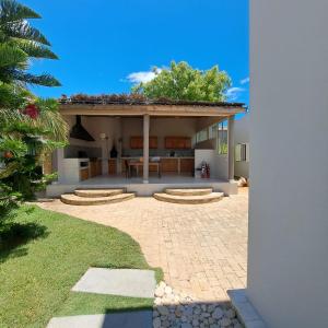 a house with a patio with a tree on top at Villa Céllia in Tsivonoakely