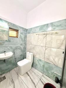 a bathroom with a toilet and a sink at Mridanga Homestay in Iritti +14 photos