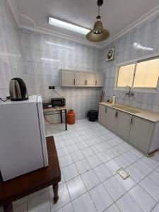 a kitchen with a white tiled floor at قصر الضيافه in Medina