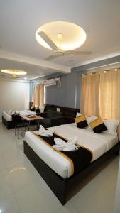a bedroom with a large bed and a living room at V-Suites in Bangalore