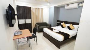 a hotel room with a bed and a chair and a table at V-Suites in Bangalore