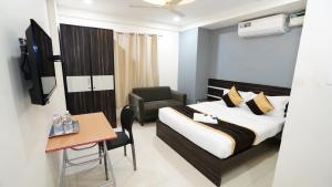 a hotel room with a bed and a chair and a table at V-Suites in Bangalore +58 photos