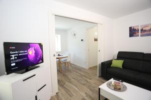 a living room with a couch and a flat screen tv at Casa Bea 3 in Castione della Presolana