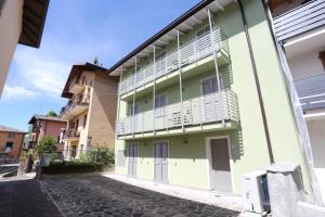 a building with white shutters on a street at Casa Bea 3 in Castione della Presolana