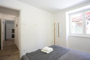 a white bedroom with a bed and a window at Casa Bea 3 in Castione della Presolana