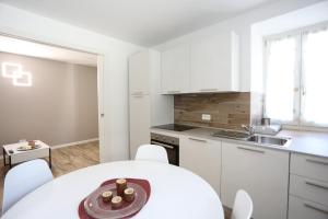 a kitchen with white cabinets and a table and chairs at Casa Bea 3 in Castione della Presolana