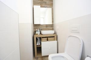 a bathroom with a white toilet and a sink at Casa Bea 3 in Castione della Presolana +6 photos