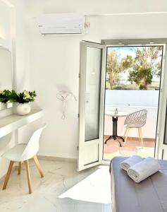 a bedroom with a bed and a table and a chair at V Angelo Prestige Rooms- Adults Only in Perissa