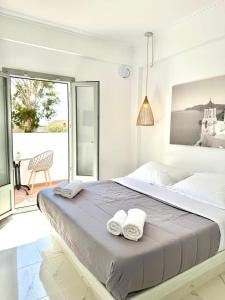 a bedroom with a large bed with two towels on it at V Angelo Prestige Rooms- Adults Only in Perissa