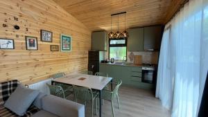 a kitchen and dining room with a table and chairs at Tianeti Apple Cottages in Churchelaurebi +24 photos