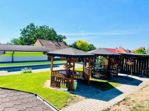 a patio with tables and umbrellas in a yard at Penzión Tyché in Šurany