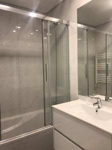 a bathroom with a shower and a sink and a tub at HabiKuchta Foz in Figueira da Foz +11 photos