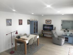 a living room with a table and a television at HabiKuchta Foz in Figueira da Foz