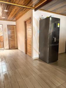 a kitchen with a stainless steel refrigerator in a room at Cabaña Kokkos Del Mar in Santa Marta