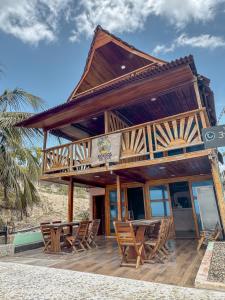 a building with chairs and a table on a beach at Cabaña Kokkos Del Mar in Santa Marta