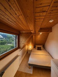 an attic bedroom with two beds and a window at Ferienwohnung Saarburg in Saarburg
