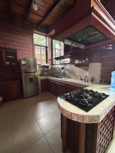 a kitchen with a stove and a refrigerator at Casa vacacional Tena Archidona in Tena +10 photos