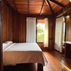 a bedroom with a bed and a large window at Casa vacacional Tena Archidona in Tena