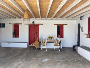 a room with two chairs and a table with a red door at Moraitis Studios in Skiros