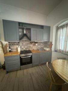 a kitchen with gray cabinets and a sink and a table at Moraitis Studios in Skiros +1 photo