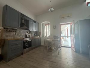 a kitchen with gray cabinets and a table with chairs at Moraitis Studios in Skiros