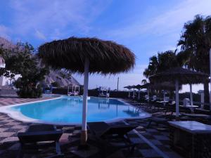 a swimming pool with umbrellas and chairs and tables at V Angelo Prestige Rooms- Adults Only in Perissa