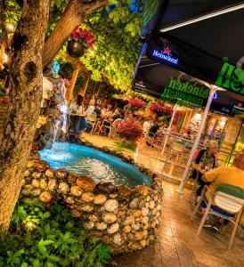 a fountain in a courtyard with people sitting at tables at Комплекс Кремен in Blagoevgrad