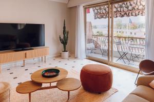 a living room with a television and a balcony at Quartier hippodrome in Cagnes-sur-Mer