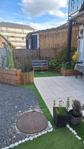 a garden with a bench and a manhole cover at Un moment d'évasion in Aulnoye-Aymeries