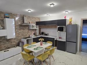 a kitchen with a table and chairs and a refrigerator at Tom Apartmans 1 in Siófok