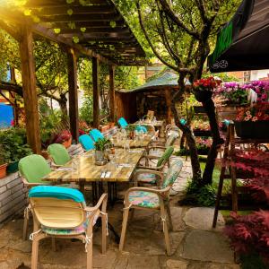 a wooden table and chairs in a garden at Комплекс Кремен in Blagoevgrad