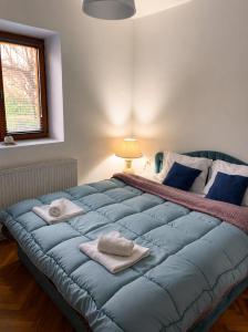 a bedroom with a large blue bed with towels on it at Garden Oasis Apartment in Veles
