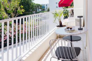 a balcony with a table and chairs and an umbrella at Quartier hippodrome in Cagnes-sur-Mer