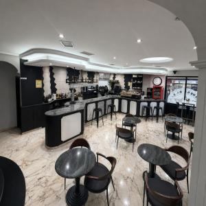 a restaurant with a bar with chairs and tables at Hostal Cafetería La Rotonda in Ourense