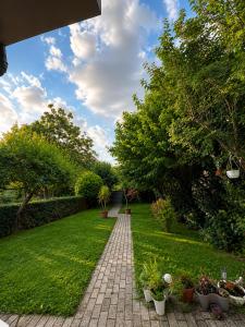a brick path through a garden with potted plants at Garden Oasis Apartment in Veles +5 photos