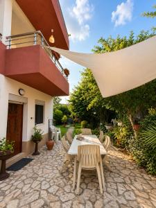 a patio with a table and chairs in front of a house at Garden Oasis Apartment in Veles