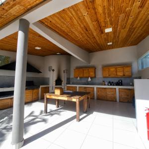 a kitchen with a wooden ceiling and a table at Villa Céllia in Tsivonoakely