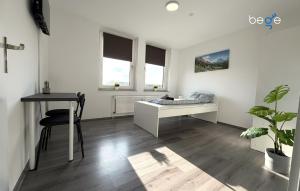 a white room with a desk and a table at BEGE APARTMENTS WorkSpace in Marl +6 photos