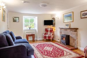 a living room with a blue couch and a fireplace at 3 Bed in Dornoch oc-o44869 in Dornoch