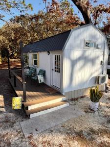a small white shed with a porch and a deck at Lemon Drop in Homosassa