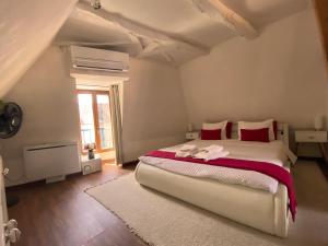 a bedroom with a large bed with red pillows at FRANRÉAL, 4 Appartements Climatisés in Sarlat-la-Canéda