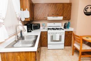 a kitchen with a sink and a stove top oven at NEW Desert Bloom Hideaway in Green Valley