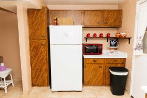 a white refrigerator in a kitchen with wooden cabinets at NEW Desert Bloom Hideaway in Green Valley +26 photos