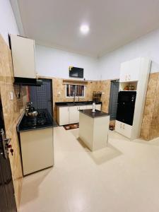 a kitchen with white cabinets and black counter tops at Kaizen Luxury Homes in Abuja