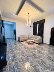 a living room with two couches and a table at Kaizen Luxury Homes in Abuja