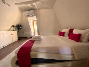 a bedroom with a large white bed with red pillows at FRANRÉAL, 4 Appartements Climatisés in Sarlat-la-Canéda +33 photos