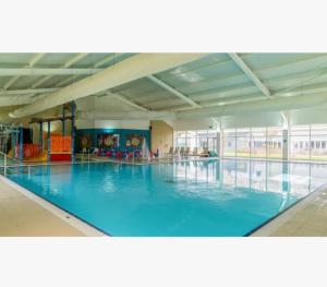 a large indoor swimming pool with blue water at Riley's Caravan sand le mere tunstall view in Tunstall
