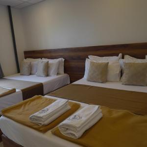 two beds in a hotel room with towels on them at Amani Beach Stay in Māvalli +43 photos